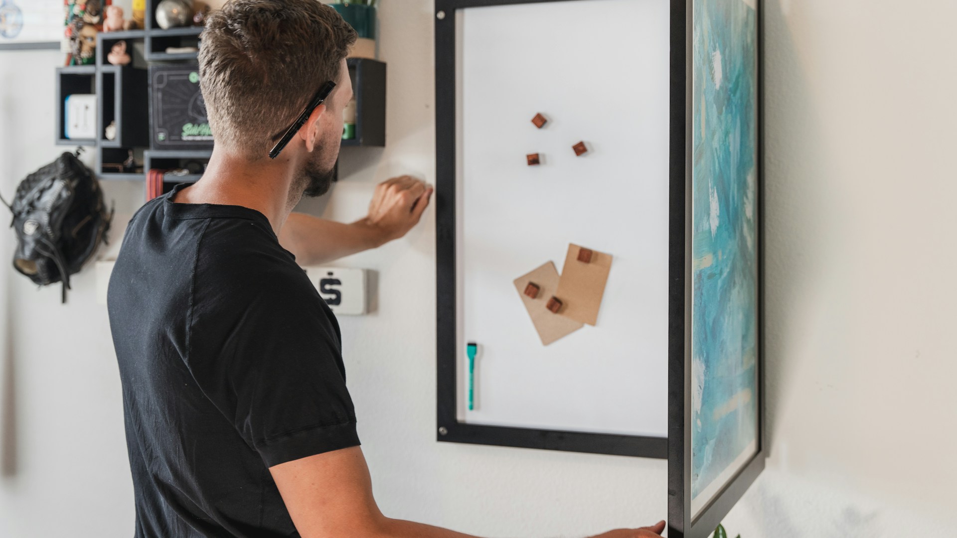 a man in a black shirt is working on a picture