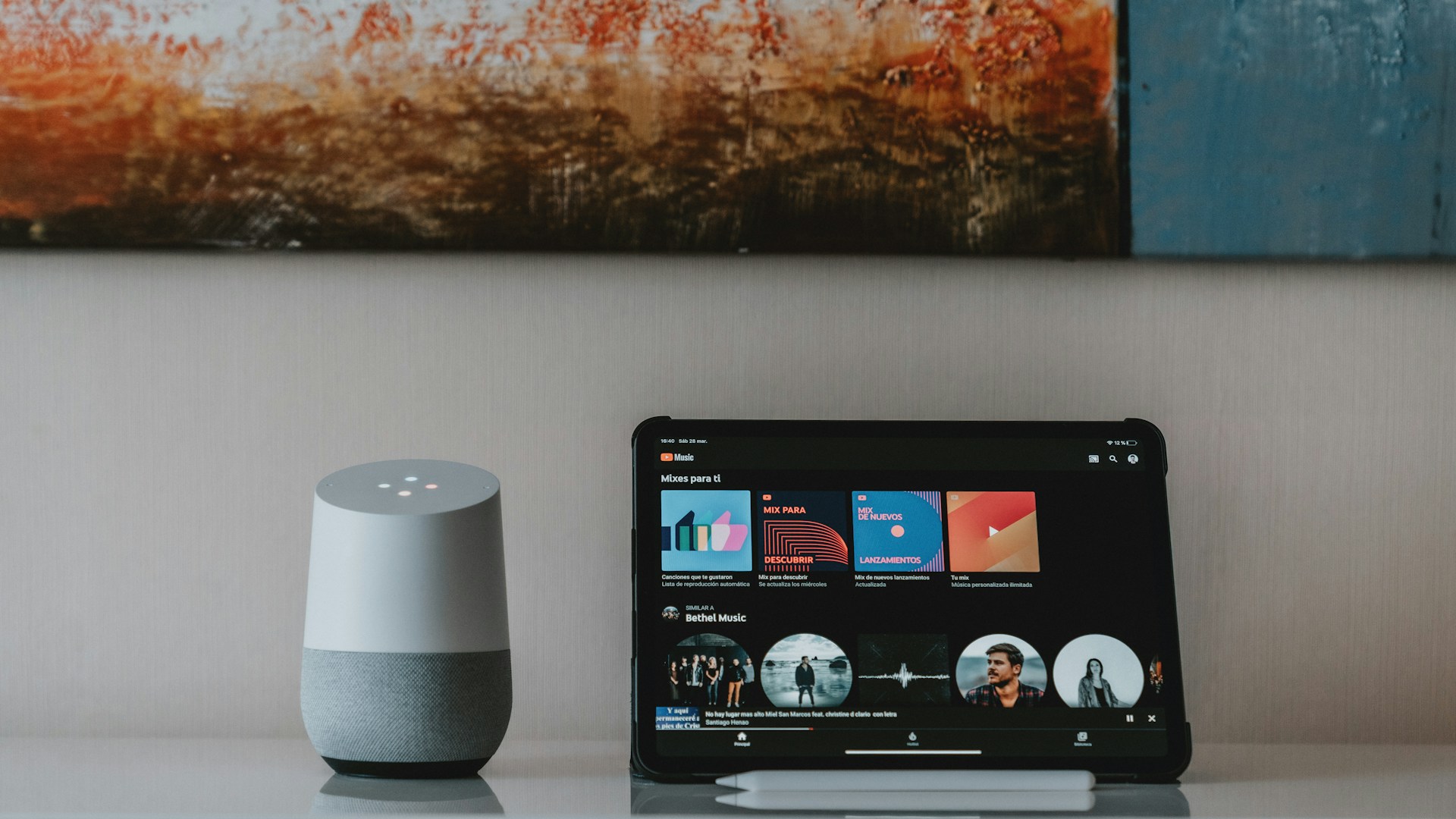 black ipad beside white portable speaker