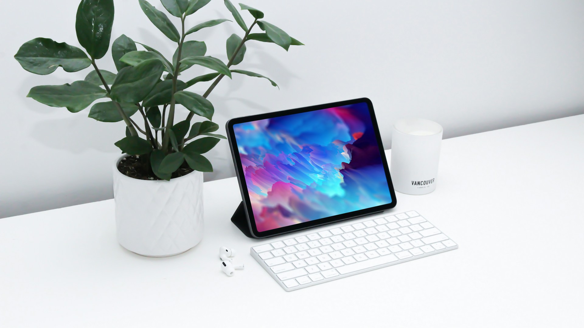 macbook pro beside green plant on white ceramic pot