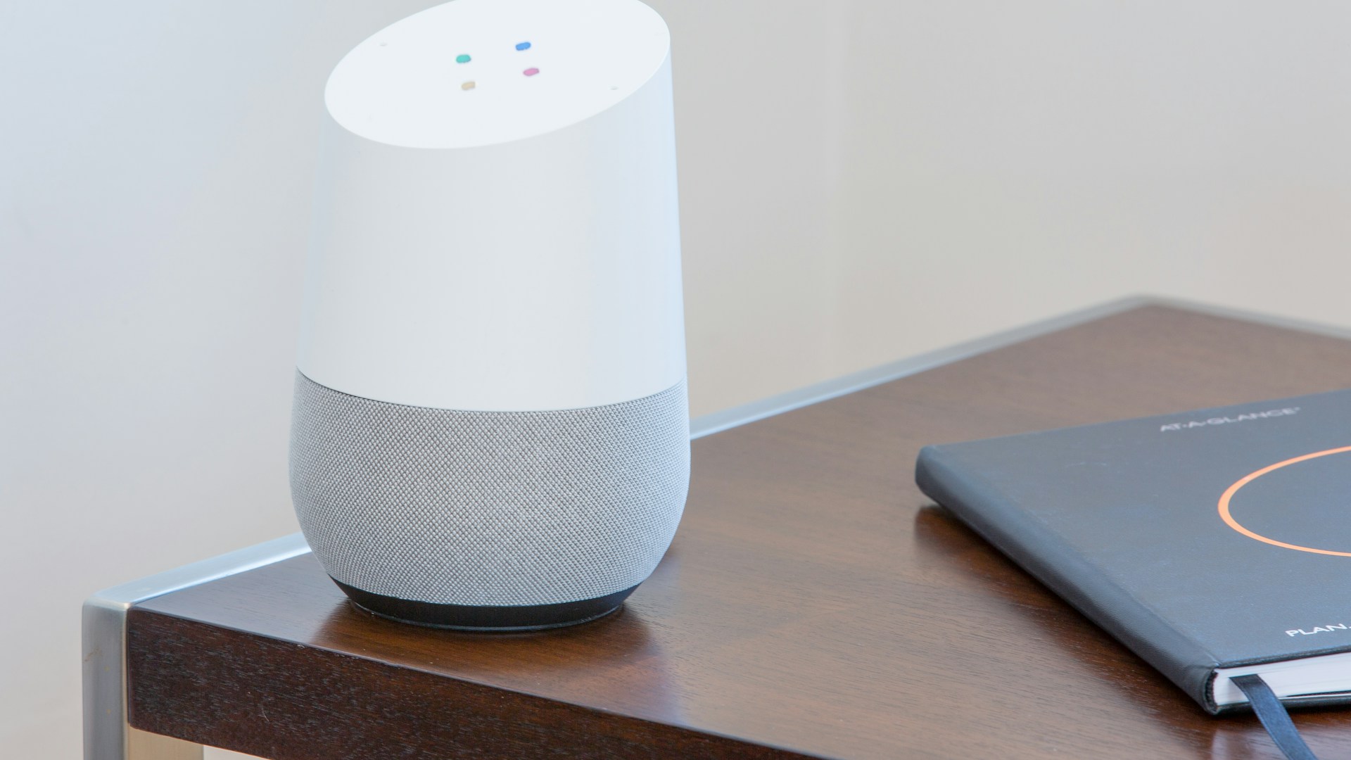 white and gray Google home on brown table