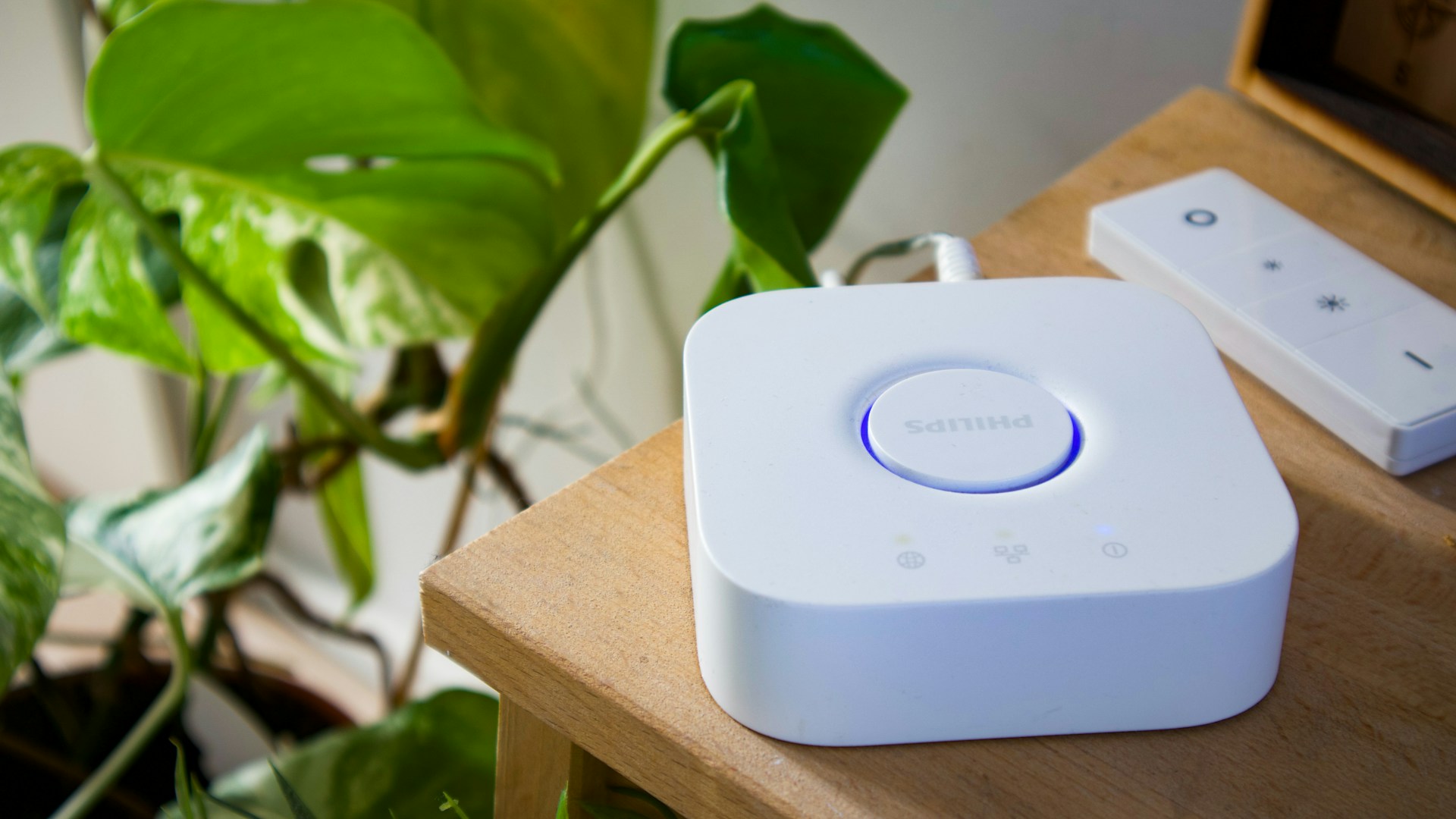 Smart home hub and remote on a wooden table.