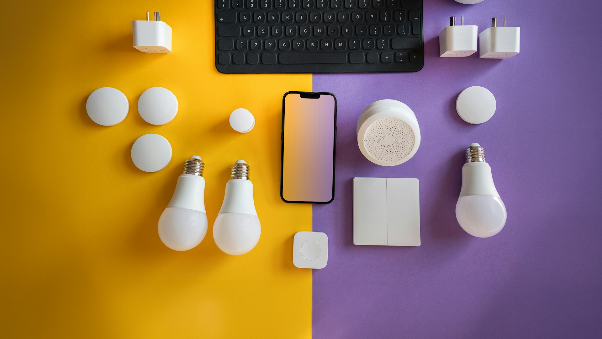 a computer keyboard, light bulbs, and other electronics on a purple and yellow background