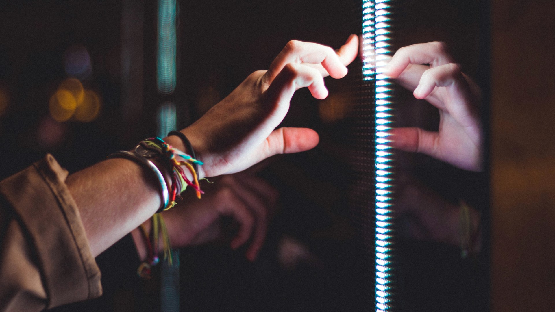 person wearing silver bracelet holding a light